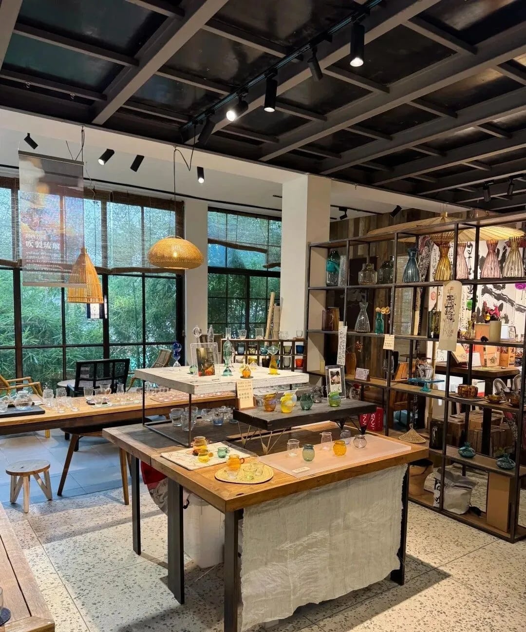 Wooden worktables and shelves beside large windows in the craft centre