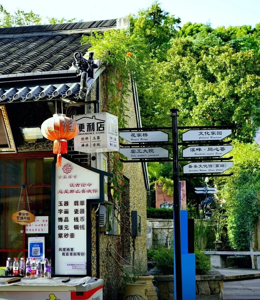 Traditional tiled buildings, a lantern and direction signs on Pingyao Old Street