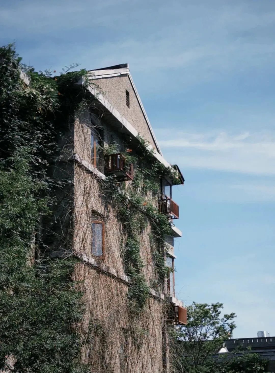 An ivy-covered old brick building beneath a blue sky in Pingyao